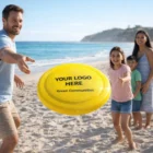 Family playing on the beach with Recycled Frisbees; frisbee displays Your Logo Here.