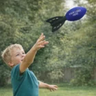 Young boy throws a Football Rockets toy with YOUR LOGO HERE in a backyard.