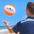 Man tossing a beach ball from our Summer Activity Sets on a sunny beach.