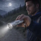 Man holds Beacon Torches flashlight on a dark forest trail under the full moon.