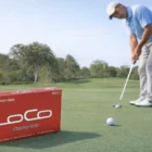 A golfer putting on a green with Golf Balls Dunlop Loco and a red box in the foreground.
