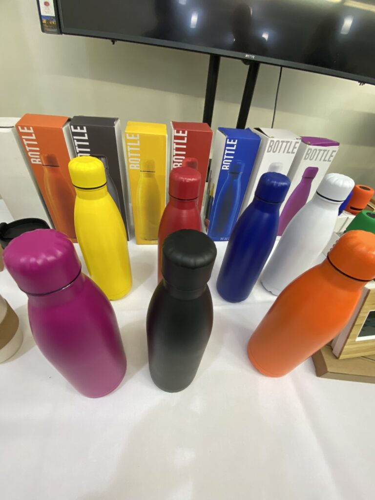 Colorful best size bottles displayed on a table with matching boxes in the background.