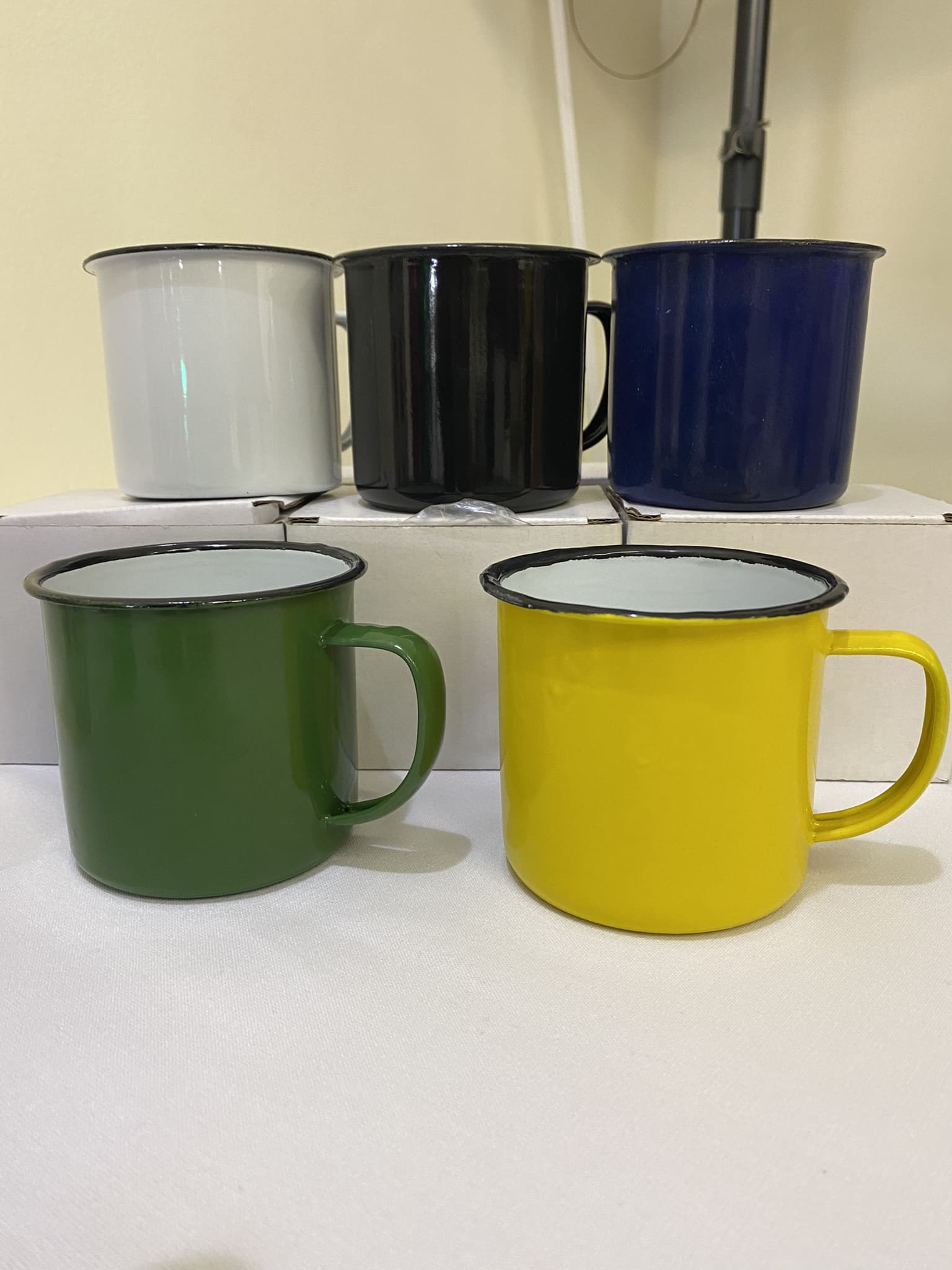 Five metal mugs—perfect as branded merchandise—are arranged on a white surface.