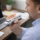 Man holding a Jumbo Stress Large Truck 16cm by a laptop, customized with "Your Logo Here".