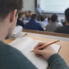 Student using a Sharpened Recycled Pencil to take notes in class during a lecture.