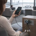 Someone charges their phone at the airport with Light Up Tech Cable Sets plugged in.