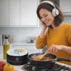 Woman in headphones cooking veggies near Nair Bluetooth Speakers.