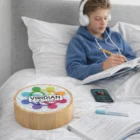 Teen boy studying in bed with headphones, notebooks, phone, and a Havant Bamboo Bluetooth Speaker.