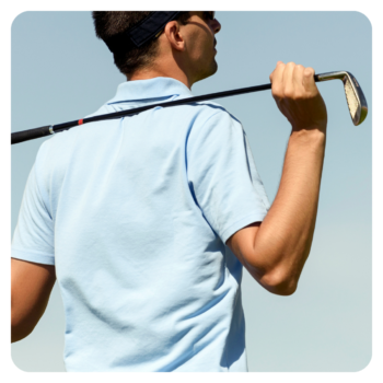 Man in a light blue corporate golf shirt holds a club over his shoulder in timeless style.