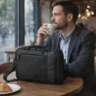 Man with Ellison Briefcase Ascott, sipping coffee and enjoying a croissant.