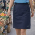 Person in Lads' Utility Cargo Skirt walks through a market with fresh vegetables.