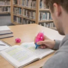 A person marks a book with The Samosir Highlighters at a library desk.
