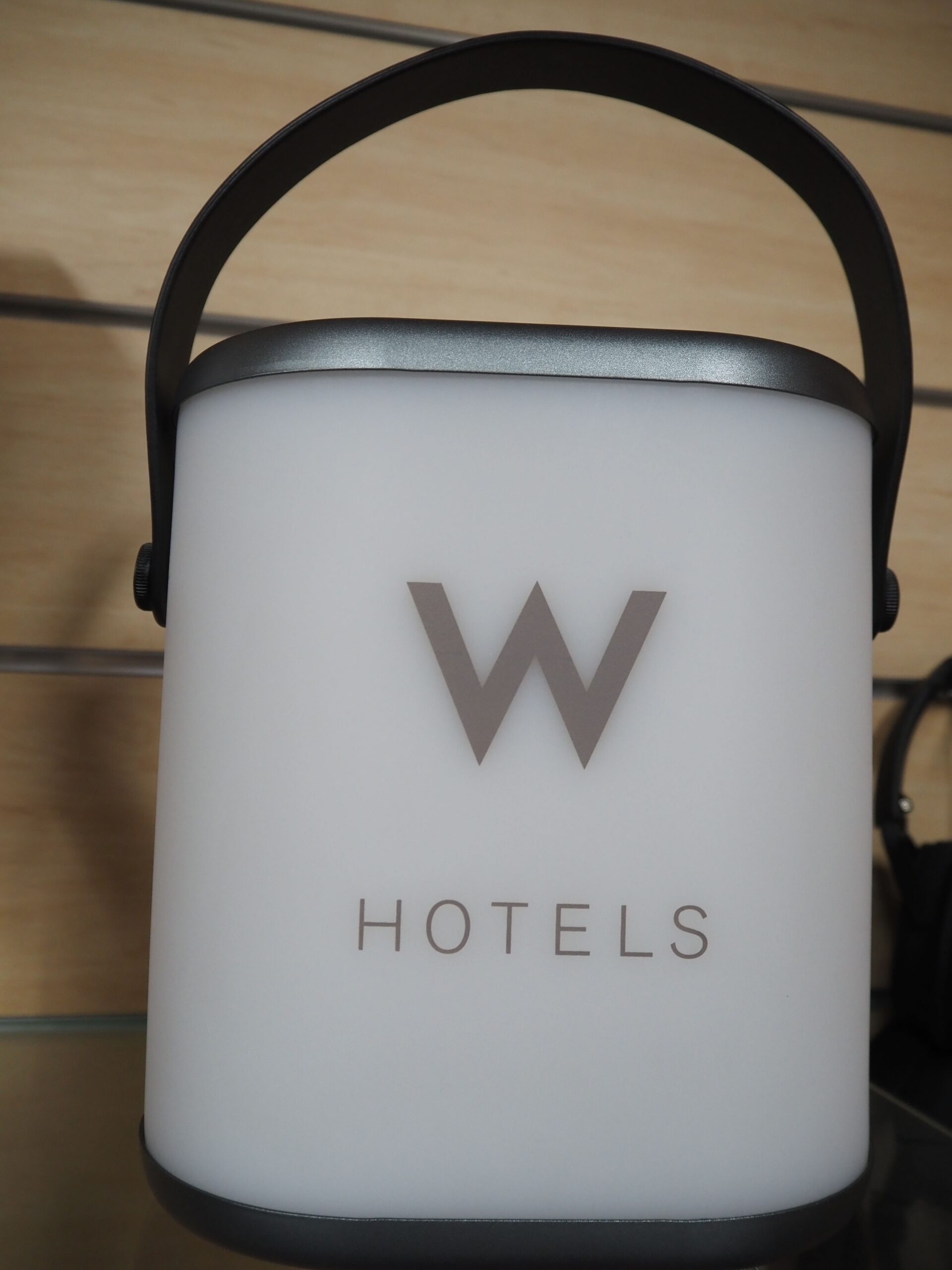 White lantern with handle, featuring W HOTELS logo—a sleek piece of physical merchandise.