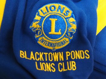 Blue and yellow Blacktown Ponds Lions Club logo embroidered—great for cheap vs. premium polo shirts.
