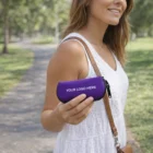 Woman in a white dress holds a purple Sunglasses Case labeled YOUR LOGO HERE in a park.