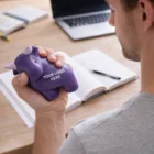 Man holding a bull stress ball for stress relief, sitting at a desk.