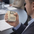 Man holding a Stress Balls Telephone at a meeting, screen blank like a stress toy.