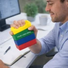 Man squeezes Stress Shaped Building Blocks toy at his computer desk.