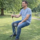 Man sitting on a Sport Seat with Your Logo Here text in a park setting.