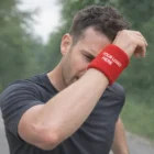 Man jogging outdoors wipes sweat with Jumbo Elastic Terrycloth Wristband featuring your logo.