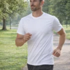 Man jogging in Stretch Fit Personalized T Shirt along park path, trees in background.