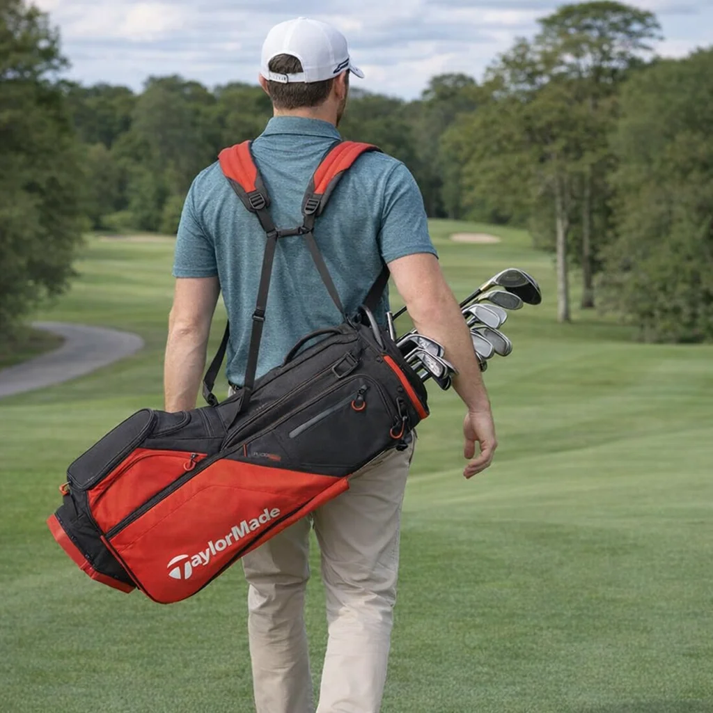 Man carrying a Taylormade Flextech Red Black Stand Bag, walking away on the golf course.
