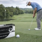 A man putting on a green with a Wilson Zip Personalized Golf Ball and box in the foreground.