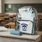 Clear backpack with notebooks on a classroom desk; empty desks and chalkboard in background.
