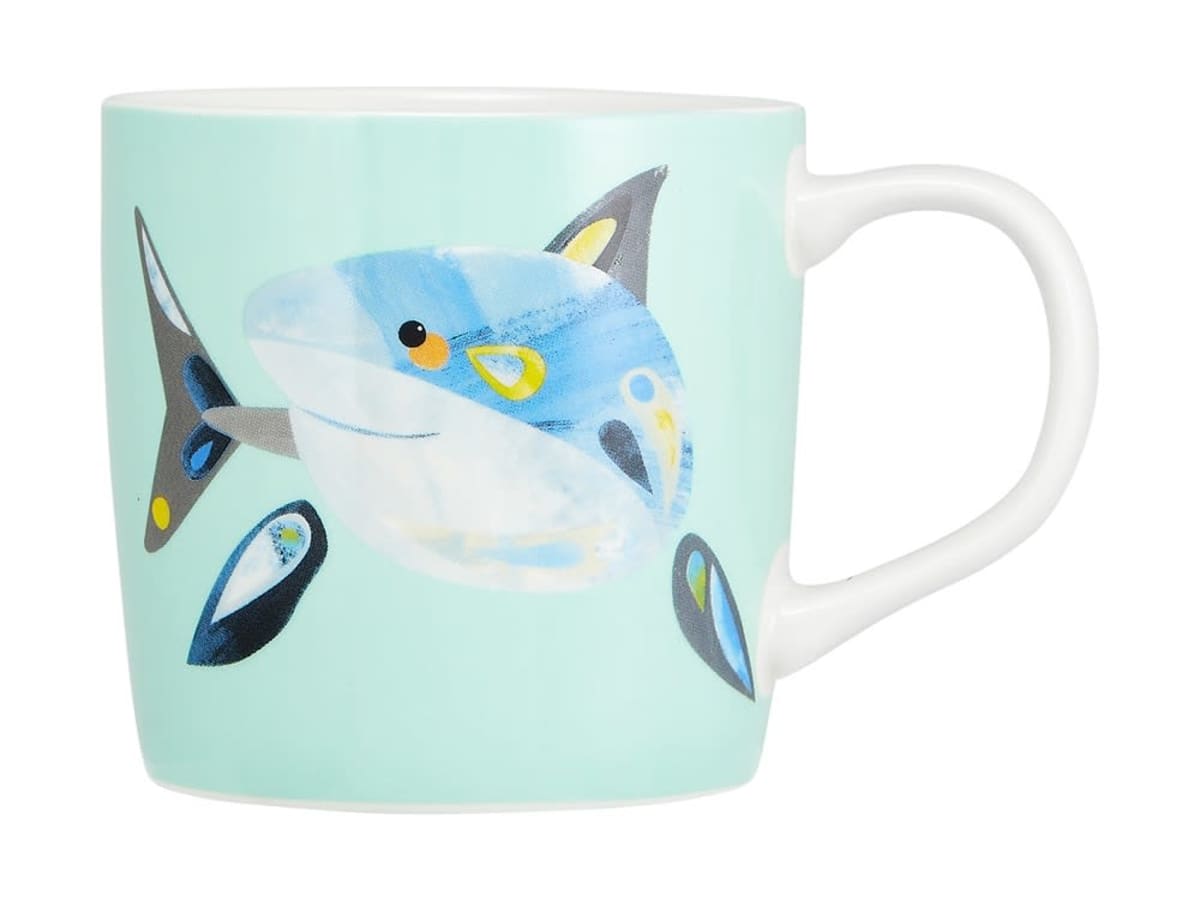 Light blue mug featuring a playful cartoon shark illustration on the side.