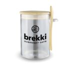 Clear jar labeled brekki overnight oats with wooden lid and spoon attached to the side.