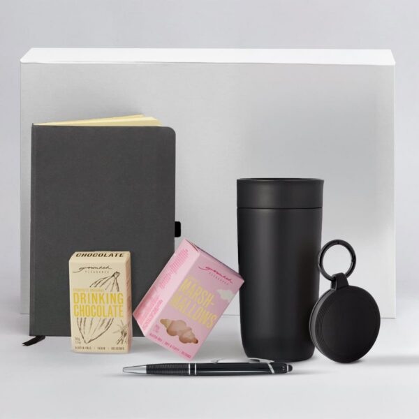 Black notebook, pen, drinking chocolate, marshmallows, black tumbler, and round black case.