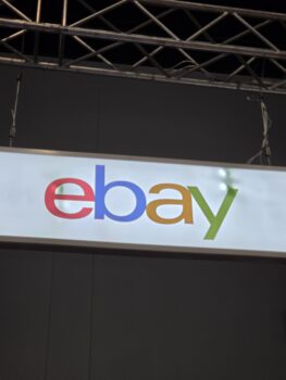 A sign with the eBay logo in colorful letters hanging from a metal frame.