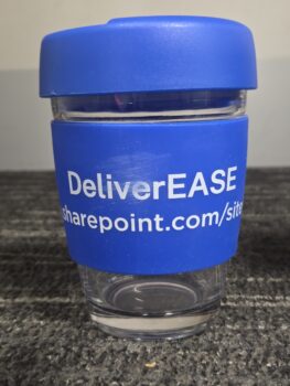 A clear cup with a blue lid and band labeled DeliverEASE sharepoint.com/sites.