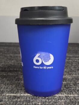 Blue reusable cup with 60 Here for 60 years printed in white on the front.