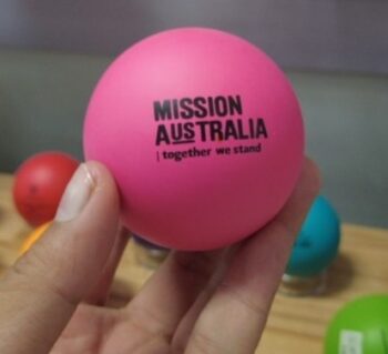 Hand holding a pink ball labeled MISSION AUSTRALIA | client advice for similar products.