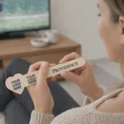Woman holding a Heart Shaped Emery Board while watching TV in the living room.