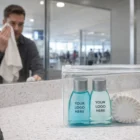 Ocean Botanicals Travel Kit with custom items, labeled bottles, man in background.