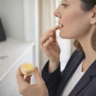 Woman applying Lip Balm Small Pot Branded Gifts—ideal for custom branded presents.