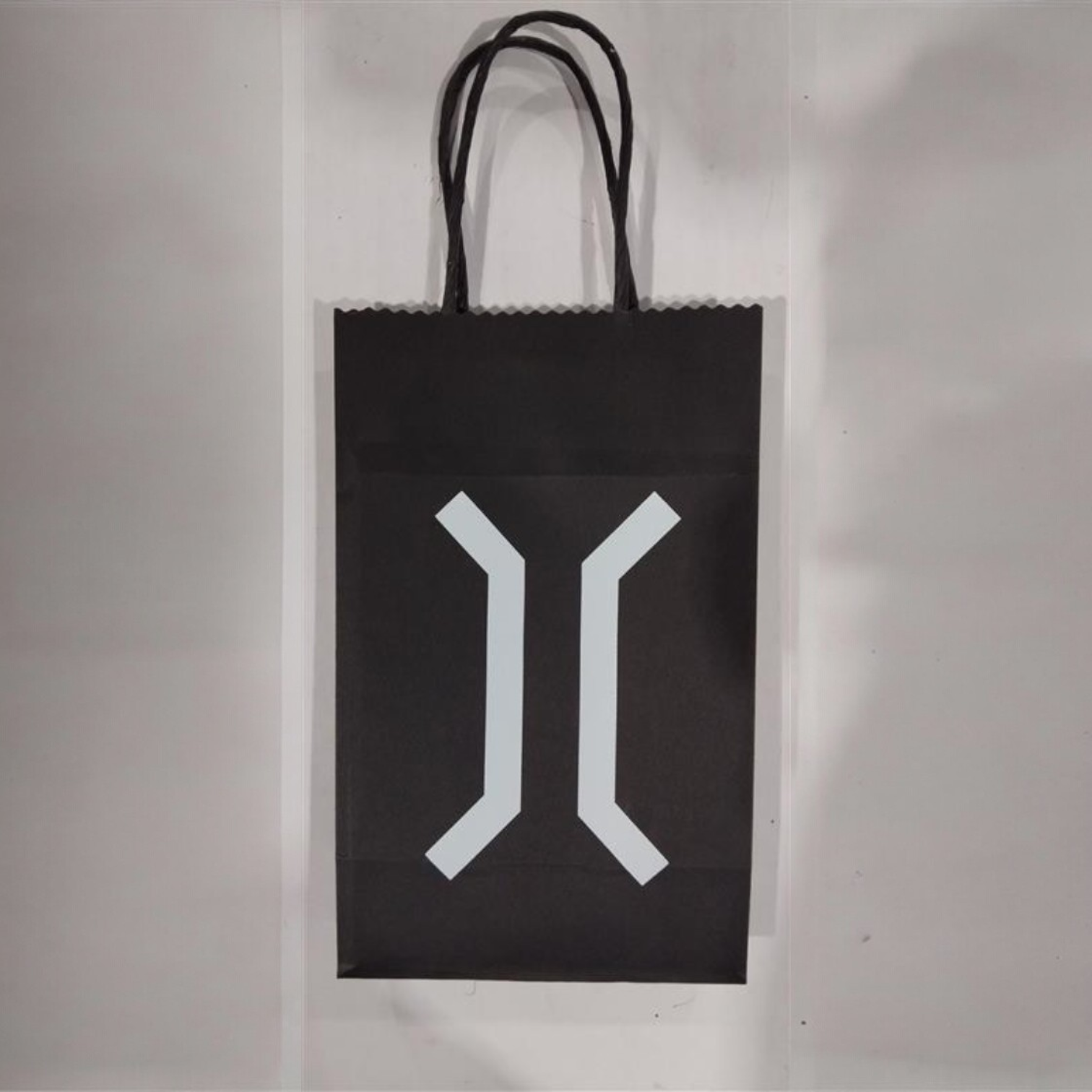 Black paper bag printed with complex co logo