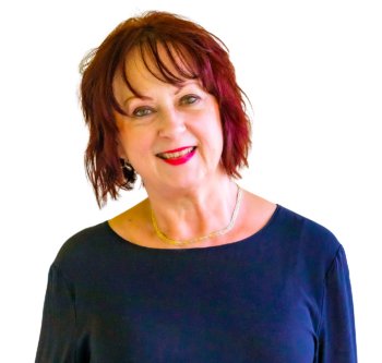 Meet the team: Smiling woman with short red hair in a dark top and gold necklace on white background.