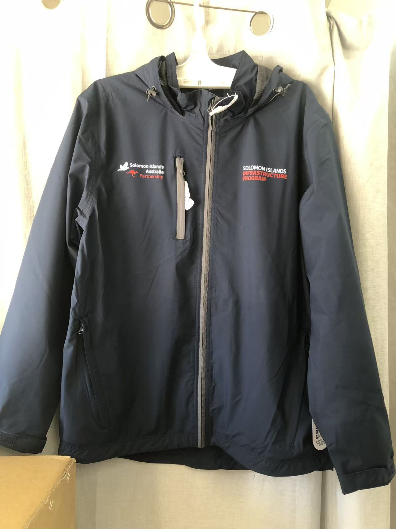Navy blue event merchandise jacket with Solomon Islands Red Cross logo and white zippered pockets.