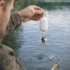 Afton holds Afton Floating Key Rings and a fishing rod above the lake, keys safe from sinking.