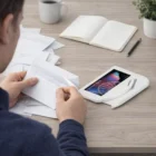 Someone opens mail with an Orion Letter Opener at a desk with a tablet, papers, and coffee.