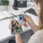 Woman cleaning glasses with Kona Polishing Cloths at her office desk.