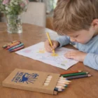 Young child coloring with Daffy Coloured Pencil Packs at a wooden table, drawing Daffy.
