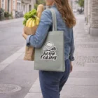 A woman with groceries carries a Budget Friendly Tote Bag on a city sidewalk.