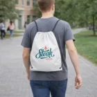 Person in a gray shirt carries a Drawstring Bag With A Full Colour Print while walking outside.