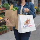 Woman with groceries in Vex Paper Carry Bags XL and a KidzLove bag near city produce stands.