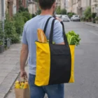 Man carrying groceries in a yellow Shakka Tote Bags while walking down the street.