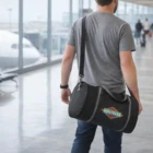 Man in gray t-shirt carrying a Mavvy Duffle Bag in an airport terminal.